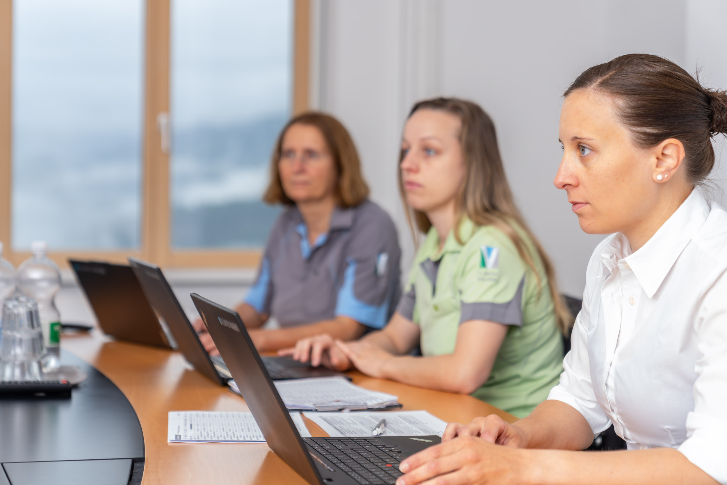 Frei junge Frauen mit Laptops an einem Besprechungstisch