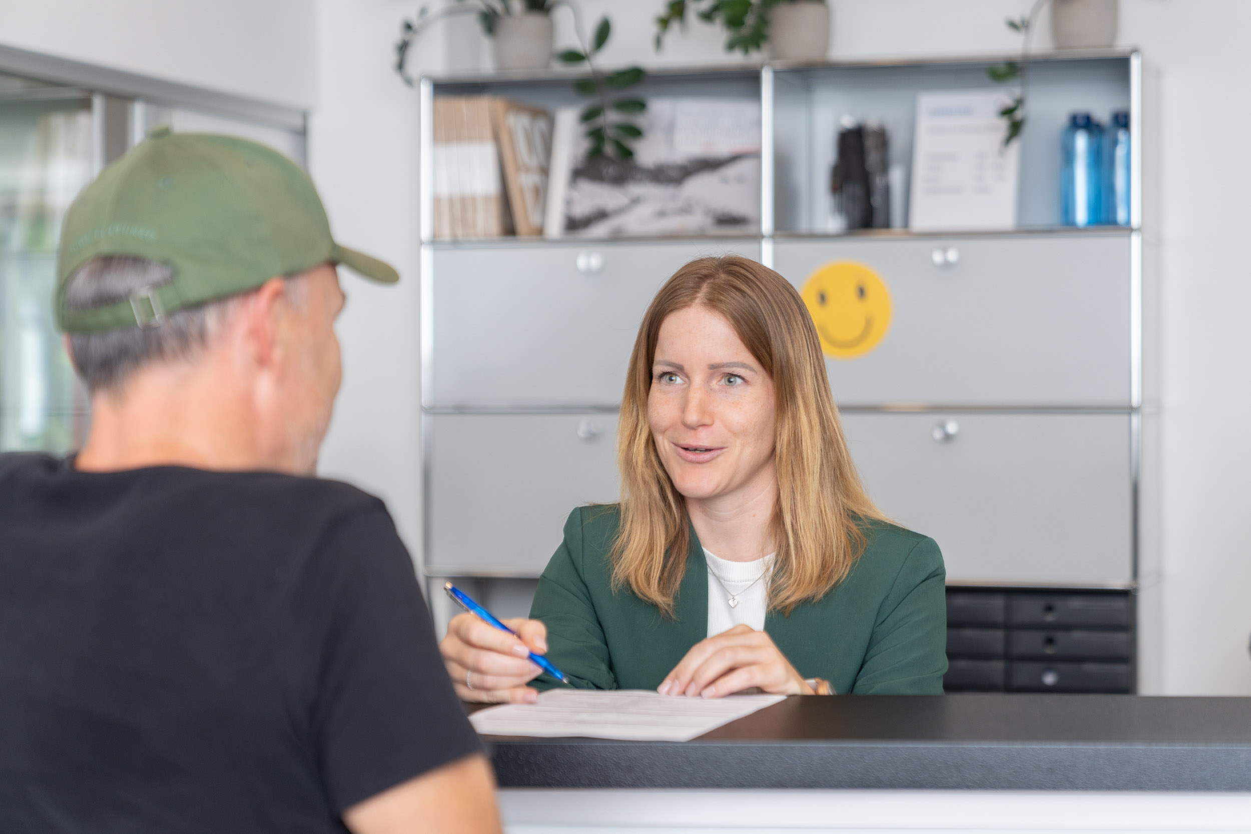 Mitarbeiterin bedient Patient an der Réception