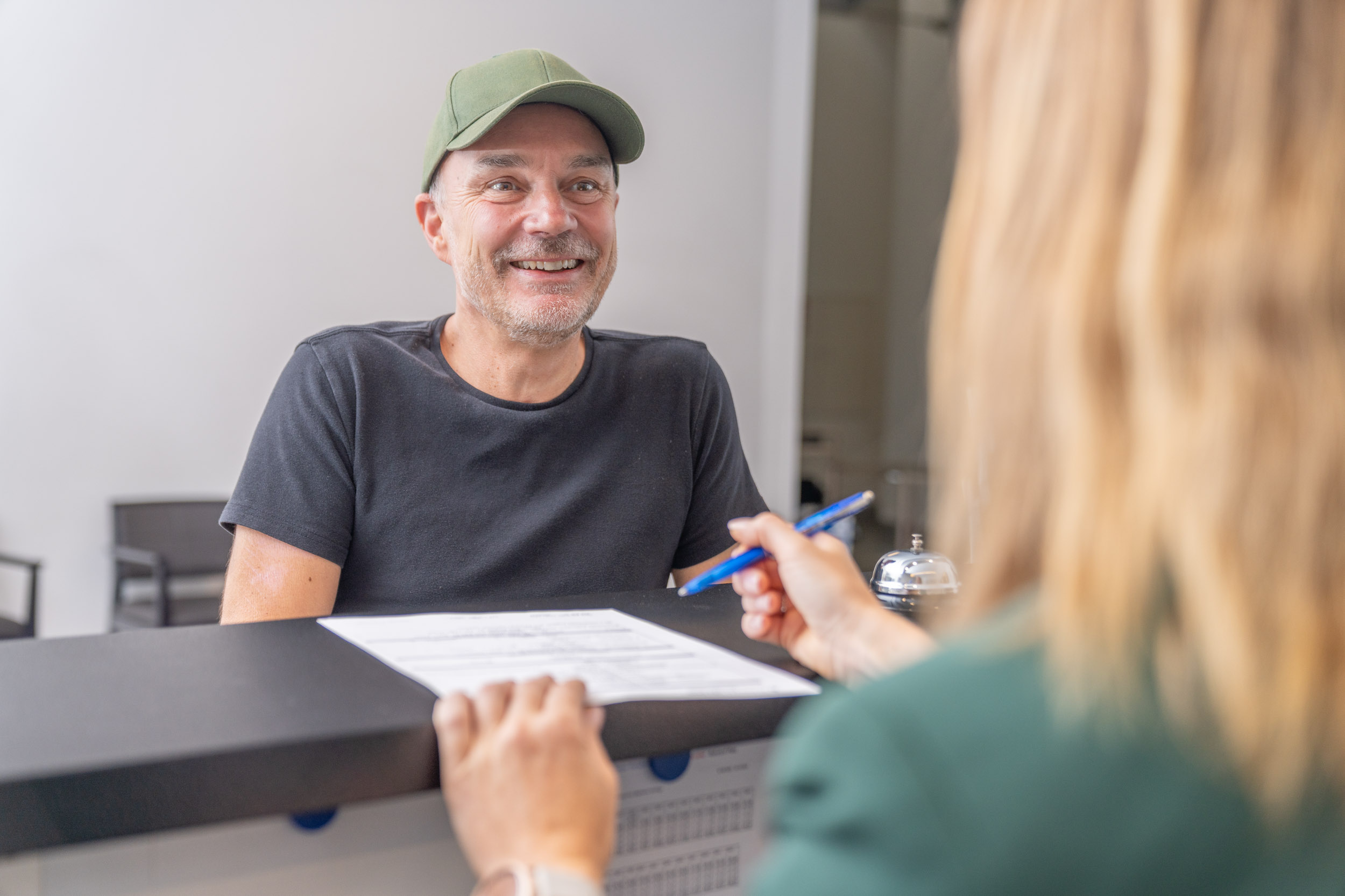 Patient im Gespräch mit Recéptionistin
