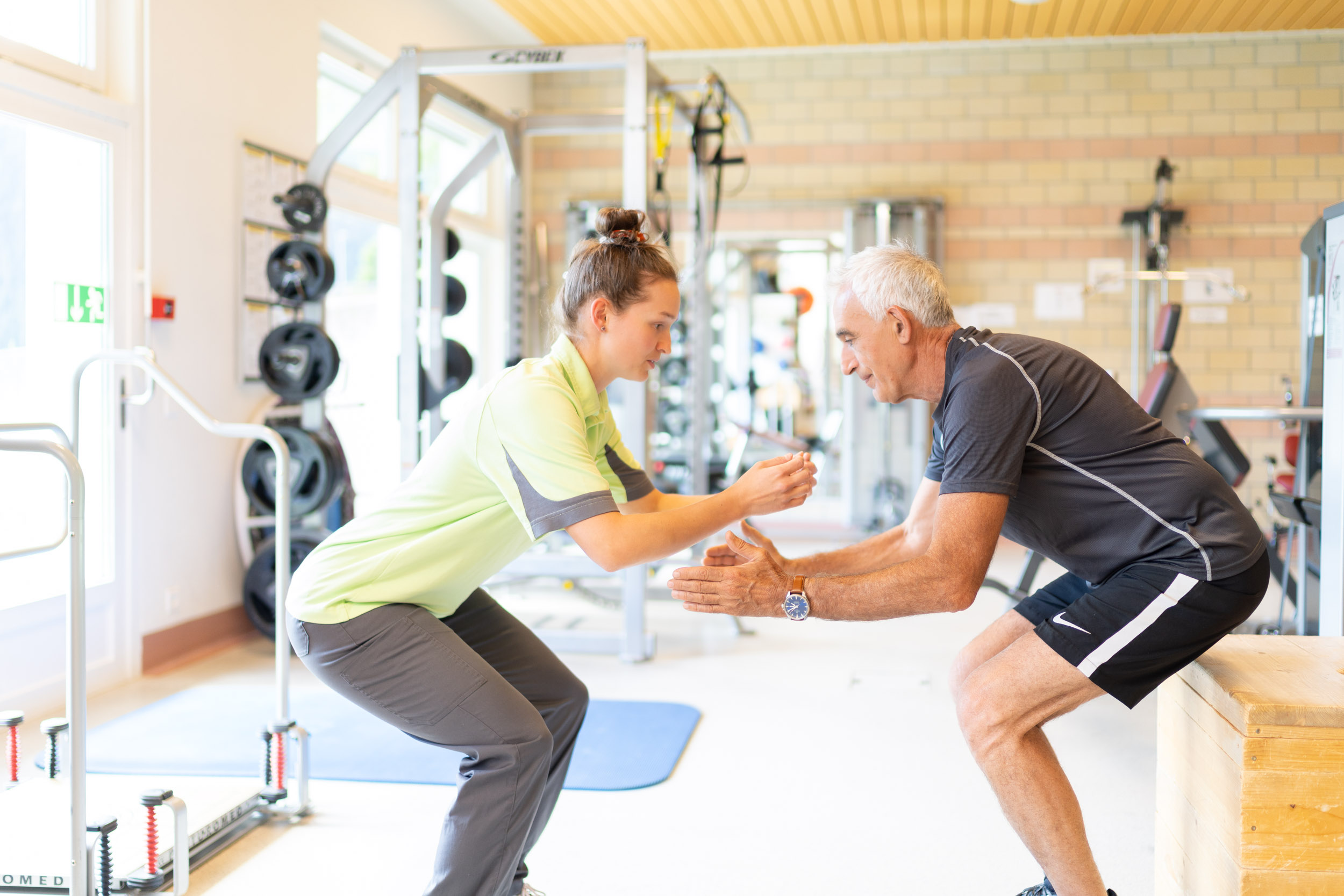 Physiotherapeutin trainiert mit älterem Patienten
