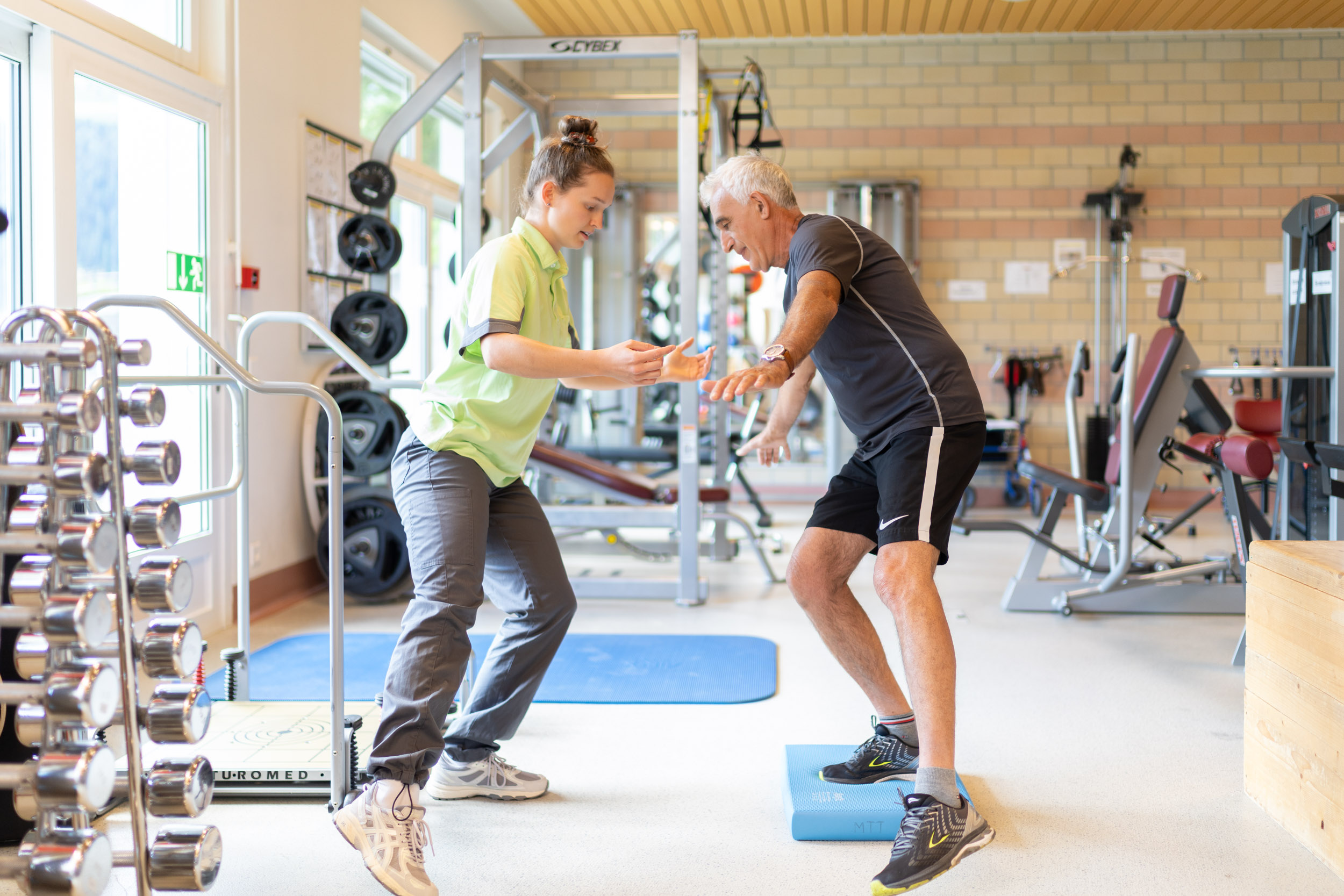 Physiotherapeutin trainiert mit älterem Patienten
