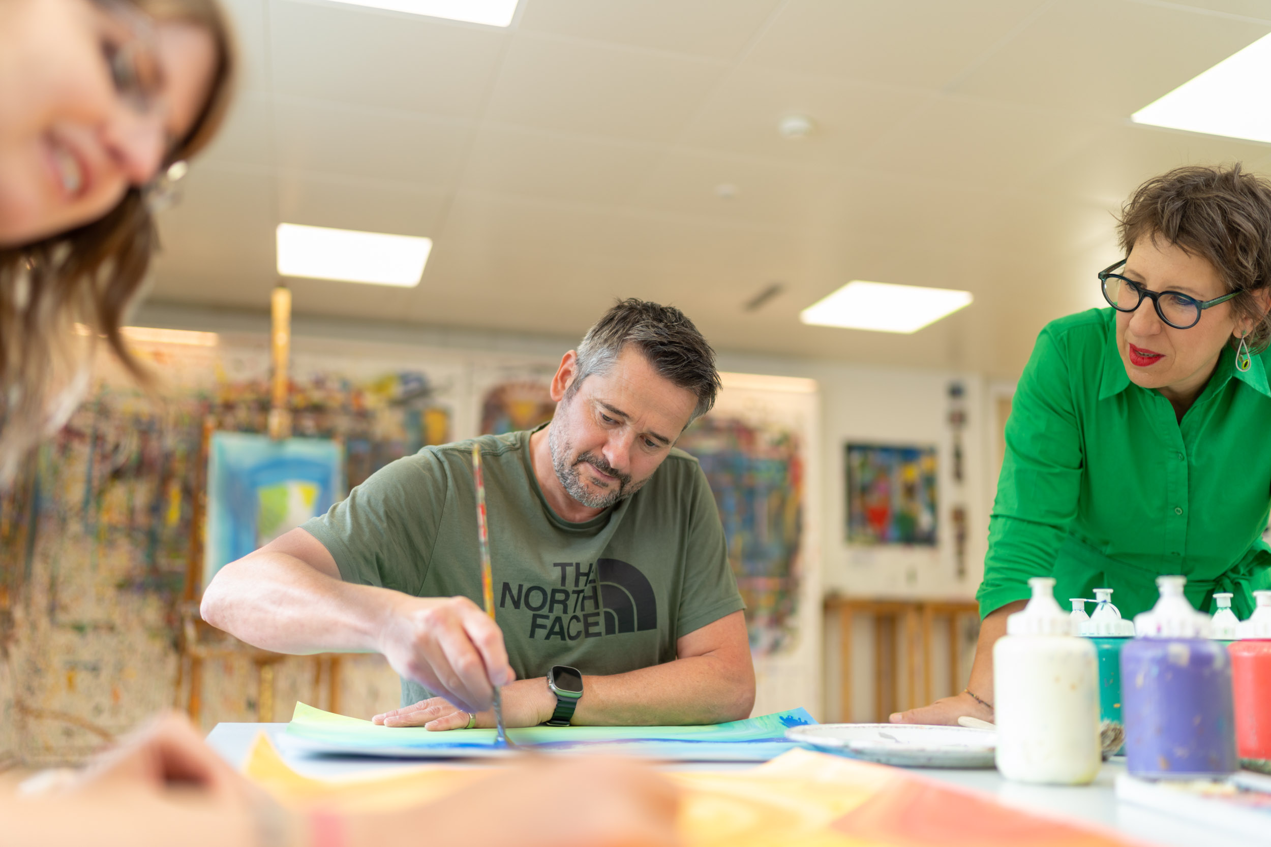 Mann mit Farben und Pinsel im Mal-Atelier