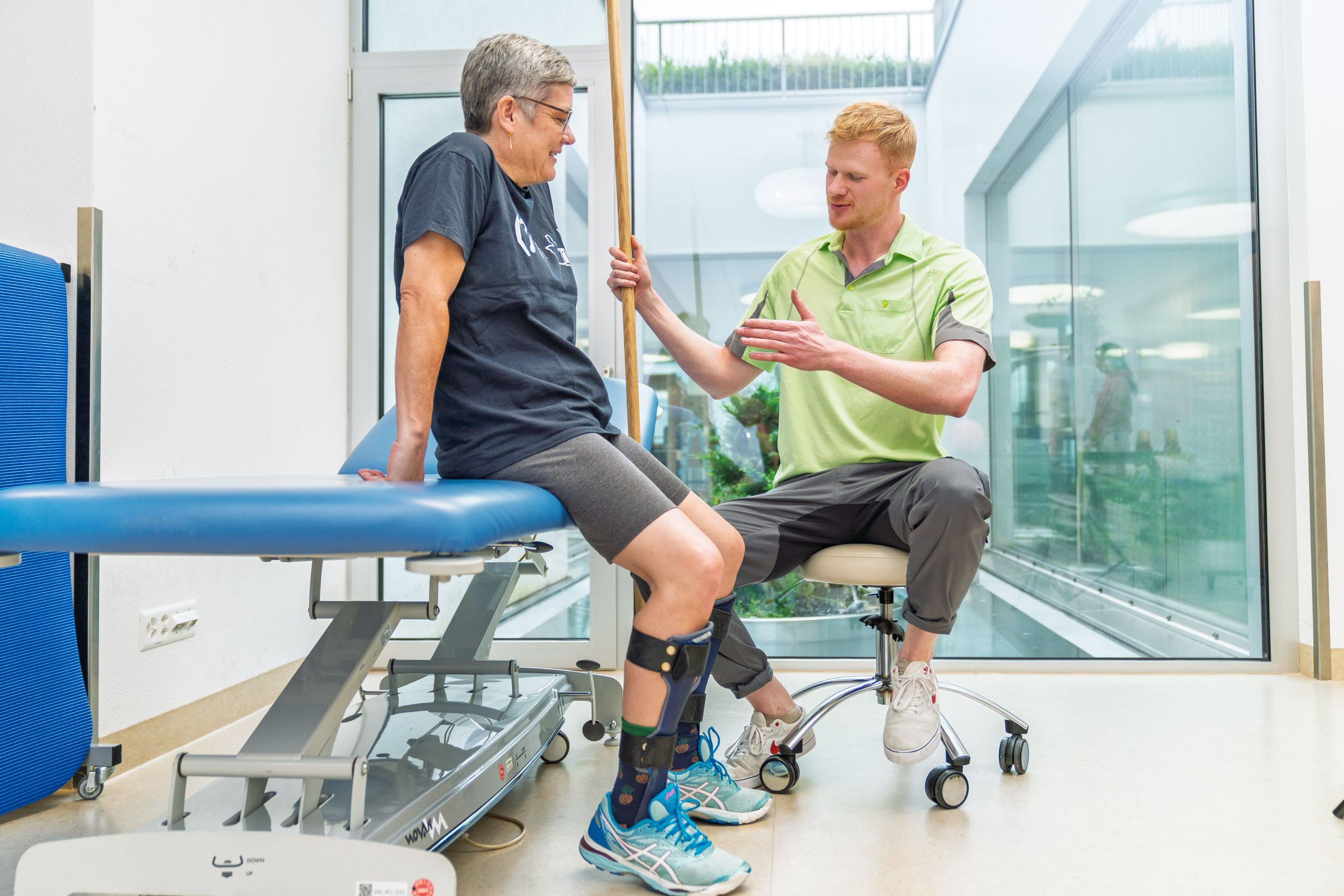 Patientin mit Physiotherapeut bei Therapieeinheit