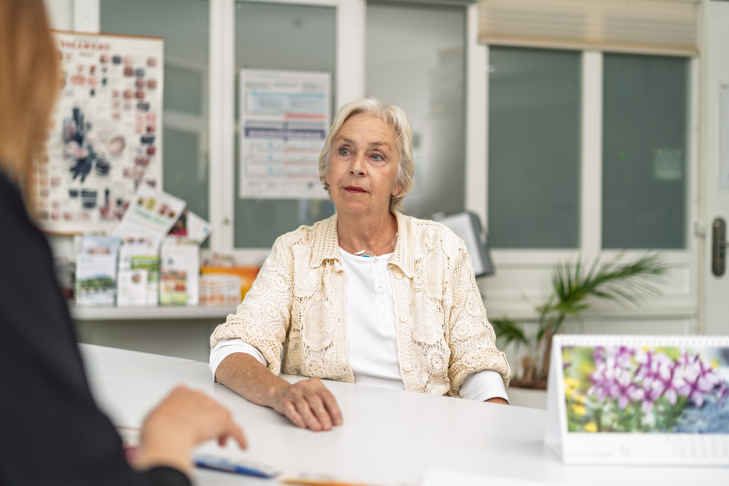 Patientin in der Beratung sitzt am Tisch