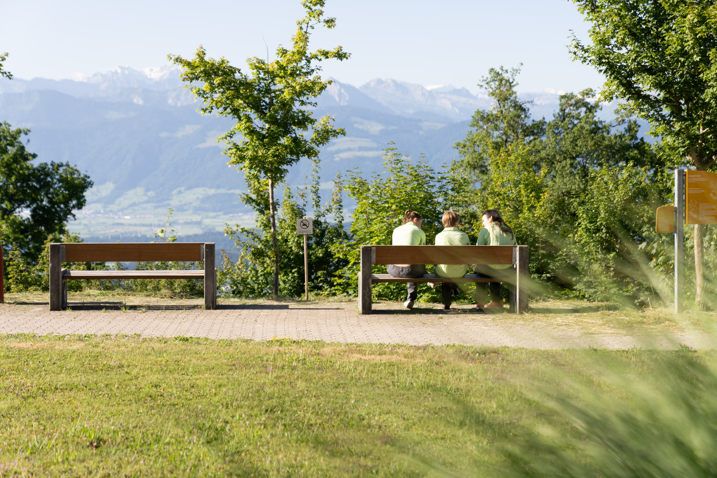 Parkbank im Grünen mit Menschen
