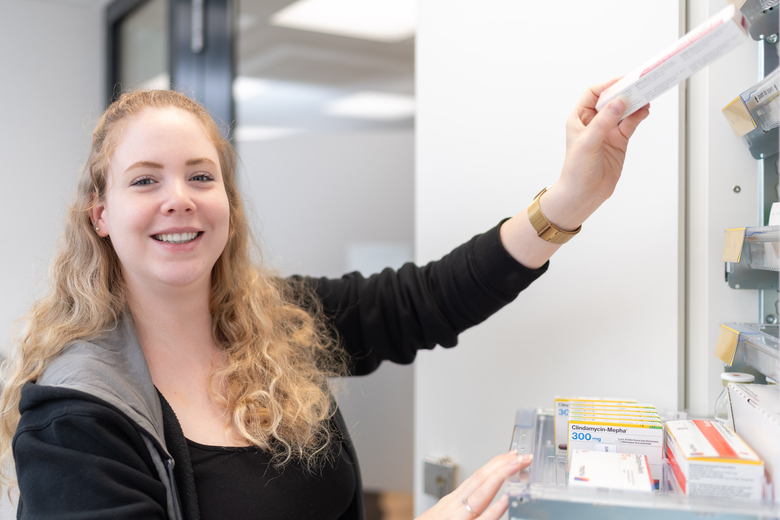 Apothekerin nimmt Medikamente aus dem Schrank