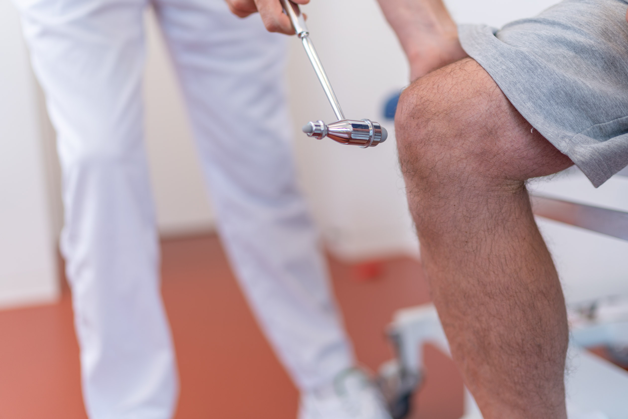 Arzt testet Kniereflex bei Patient
