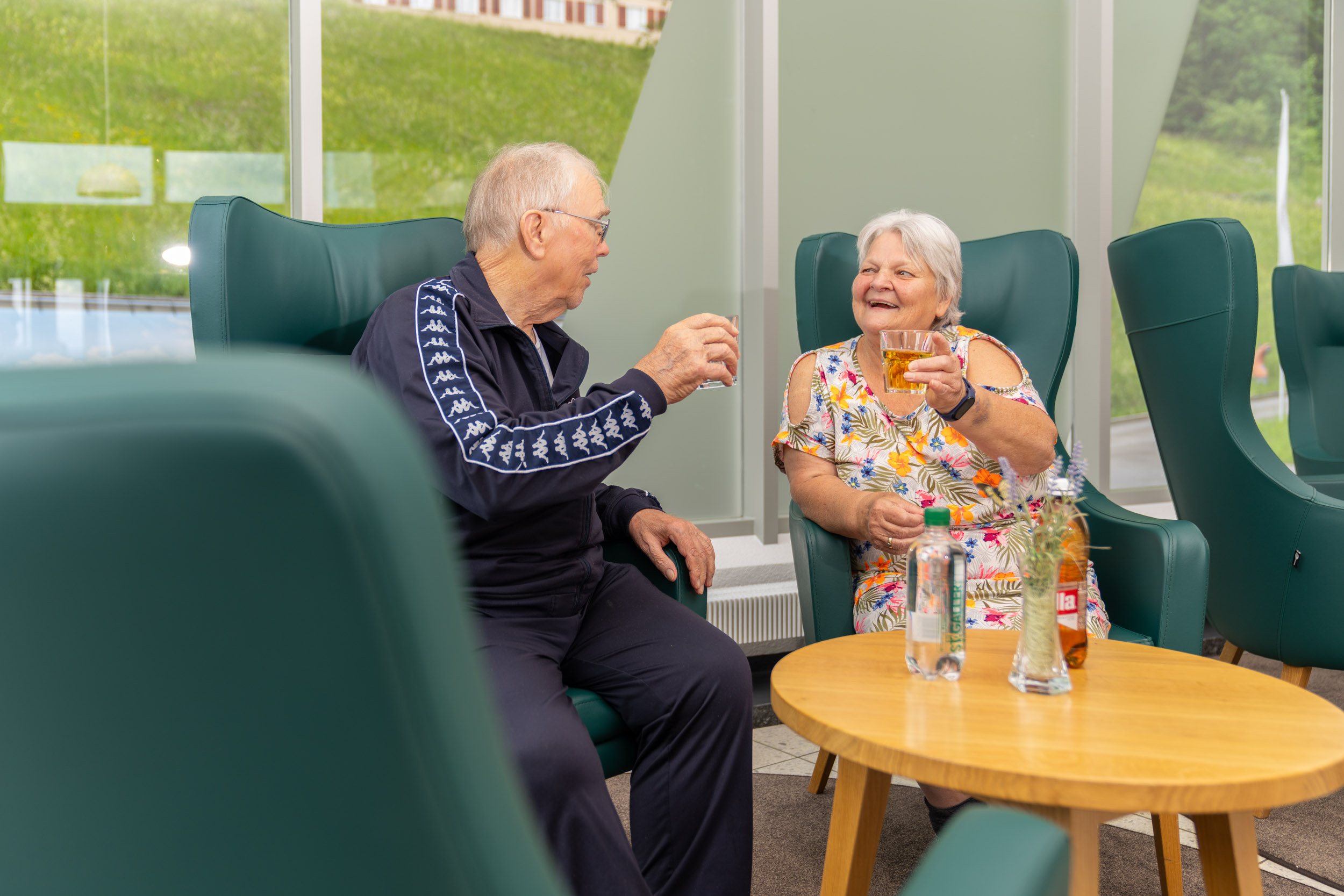 Älterer Mann und ältere Frau sitzen bei einem Glas Wasser zusammen