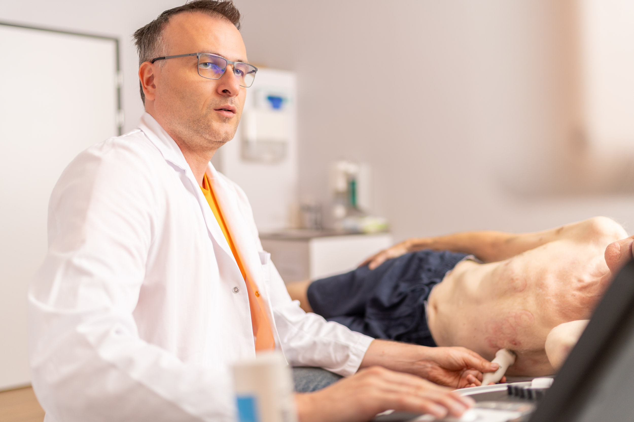 Arzt untersucht Patient mit Ultaschallgerät