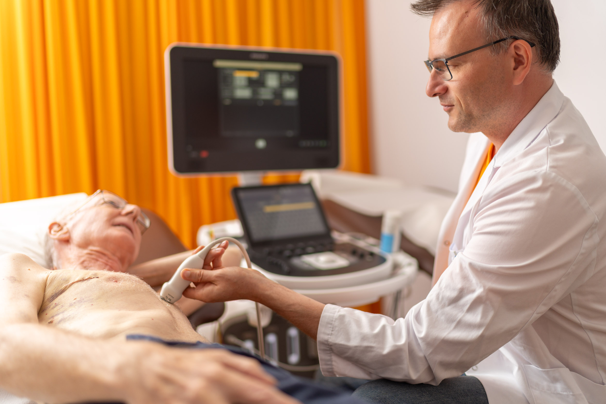 Arzt untersucht Patient mit Ultraschallgerät
