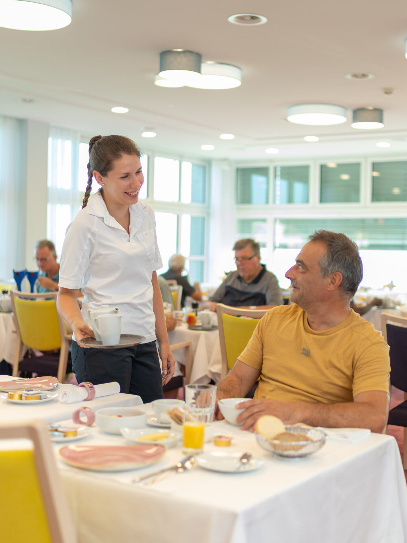 Servicemitarbeiterin bei der Bedienung eines Gastes im Speisesaal