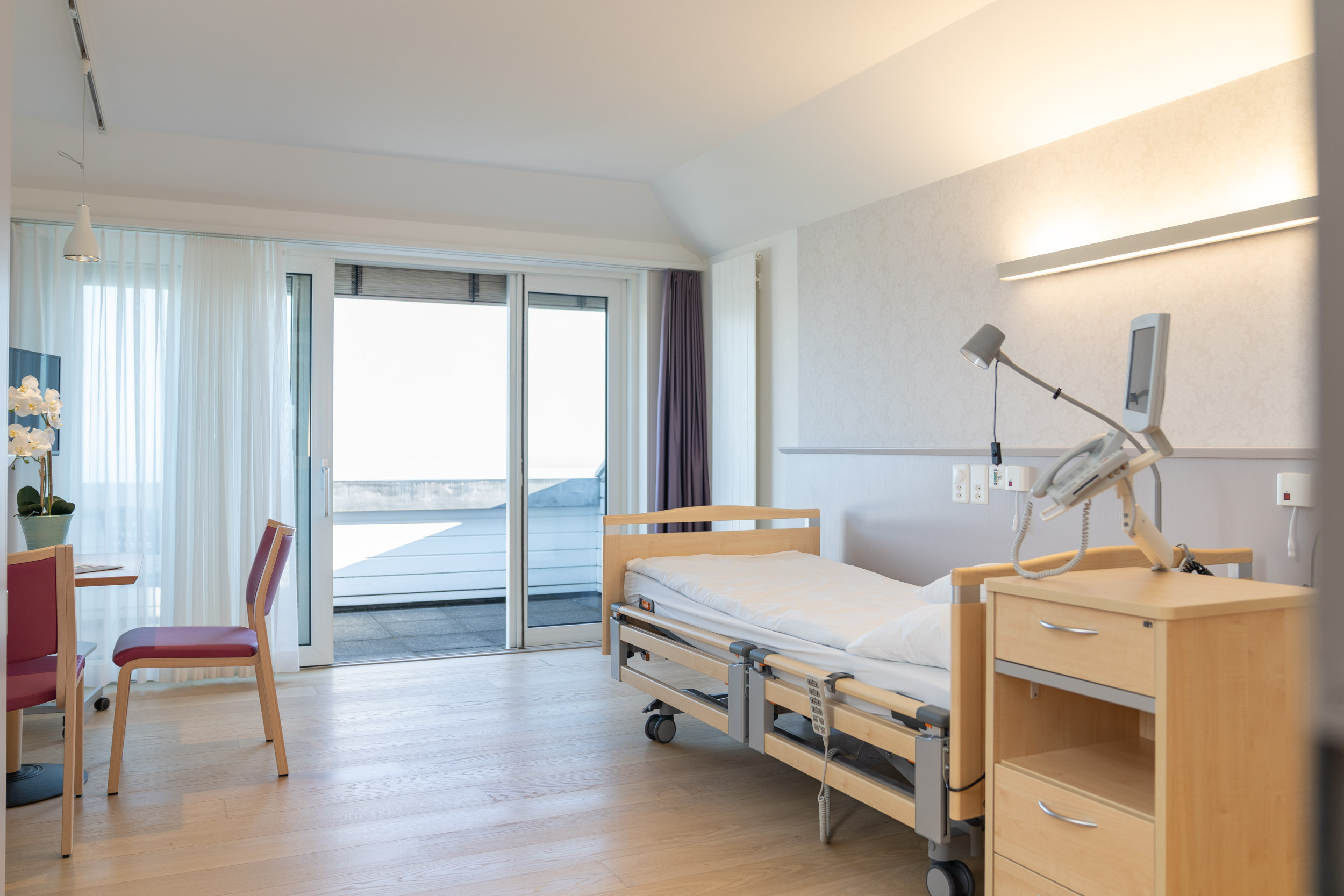 Patientenzimmer mit Bett vor dem Fenster mit Aussicht auf den Bodensee