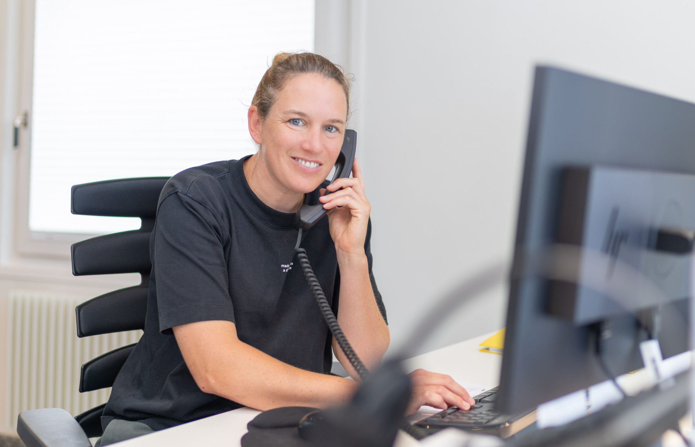 Mitarbeiterin Therapieplanung am Telefon vor PC