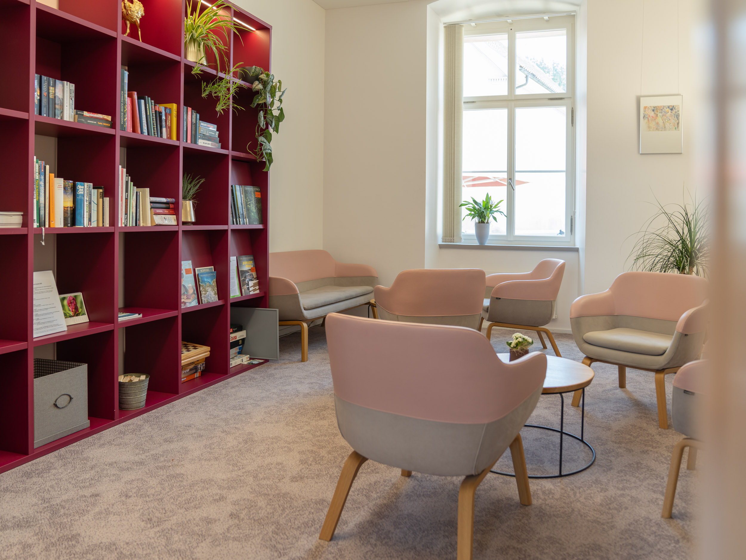 Bibliothek; Bücherwand mit Stühlen und Tisch davor