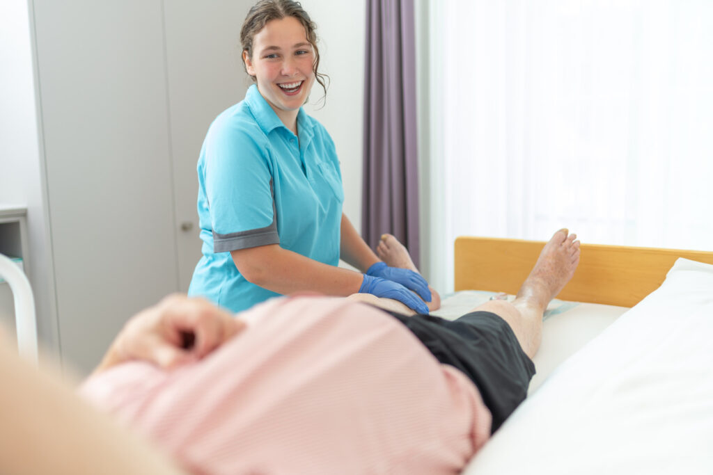 Junge Pflegefachfrau am Patientenbett