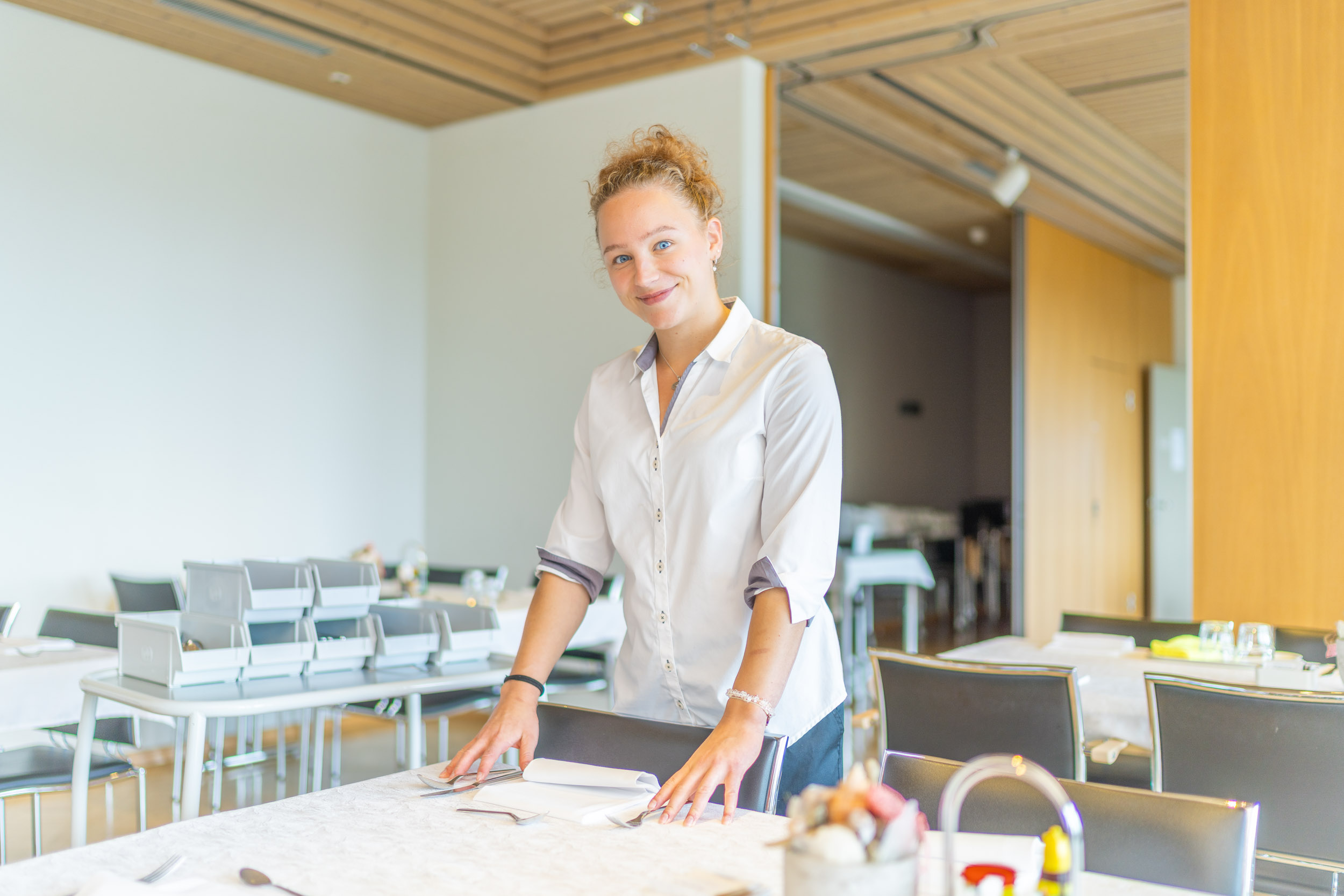 Servicemitarbeiterin deckt den Tisch