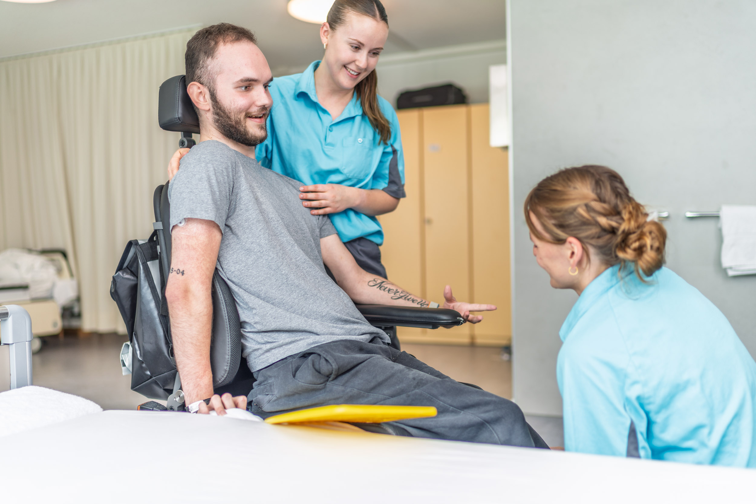 Zwei Pflegefachfrauen mit Patient im Rollstuhl