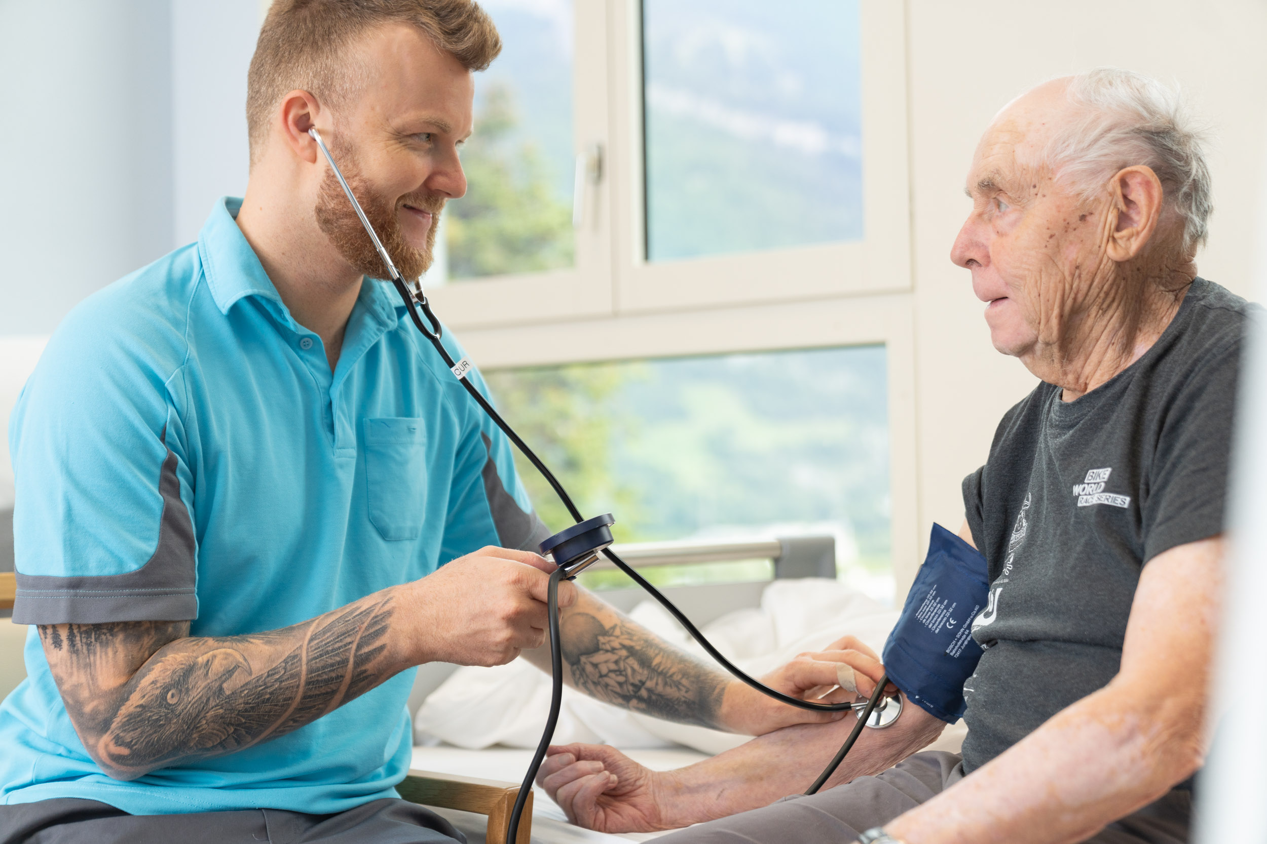 Pflegefachmann misst älterem Patient den Blutdruck