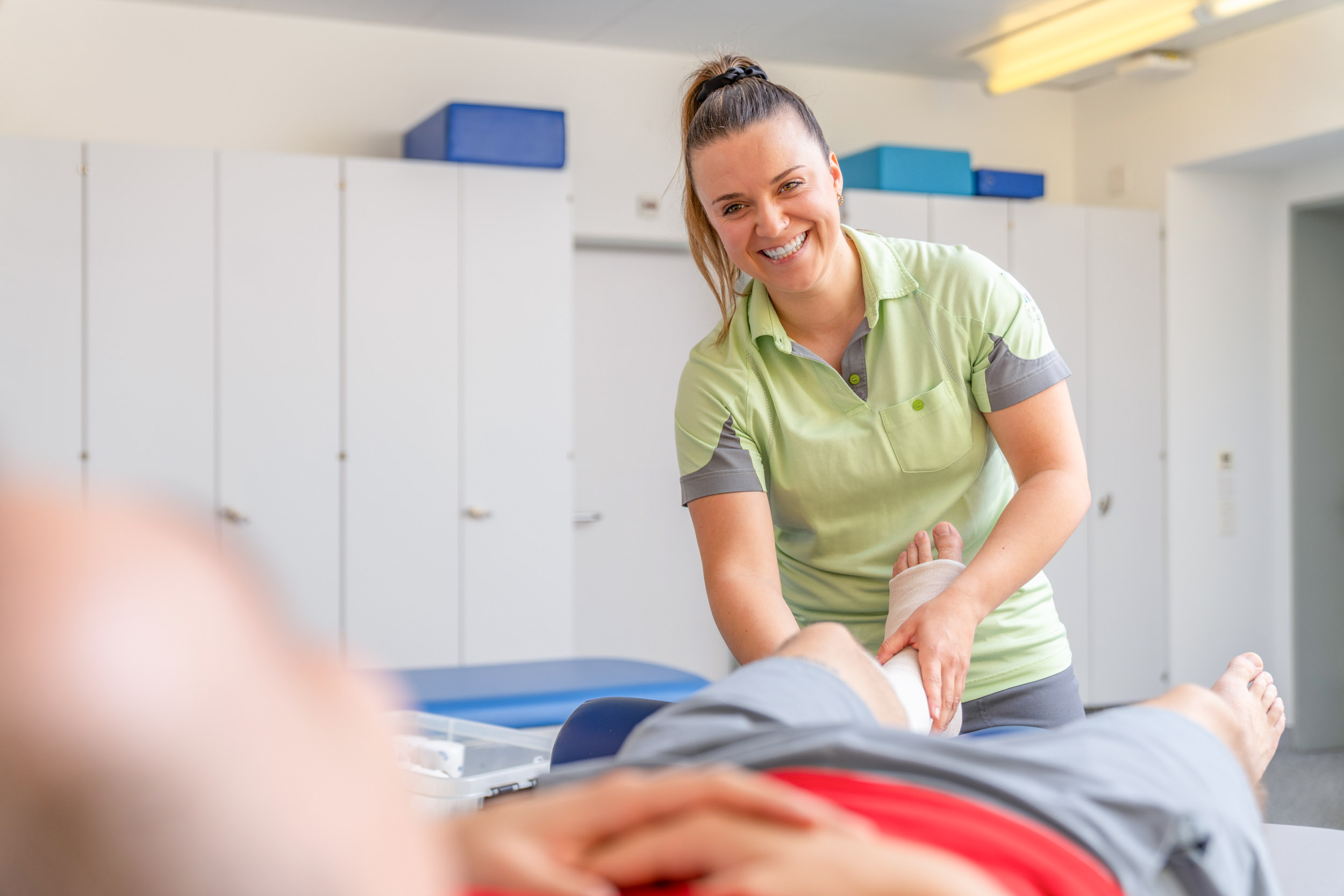 Therapeutin mit Patient auf einer Liege