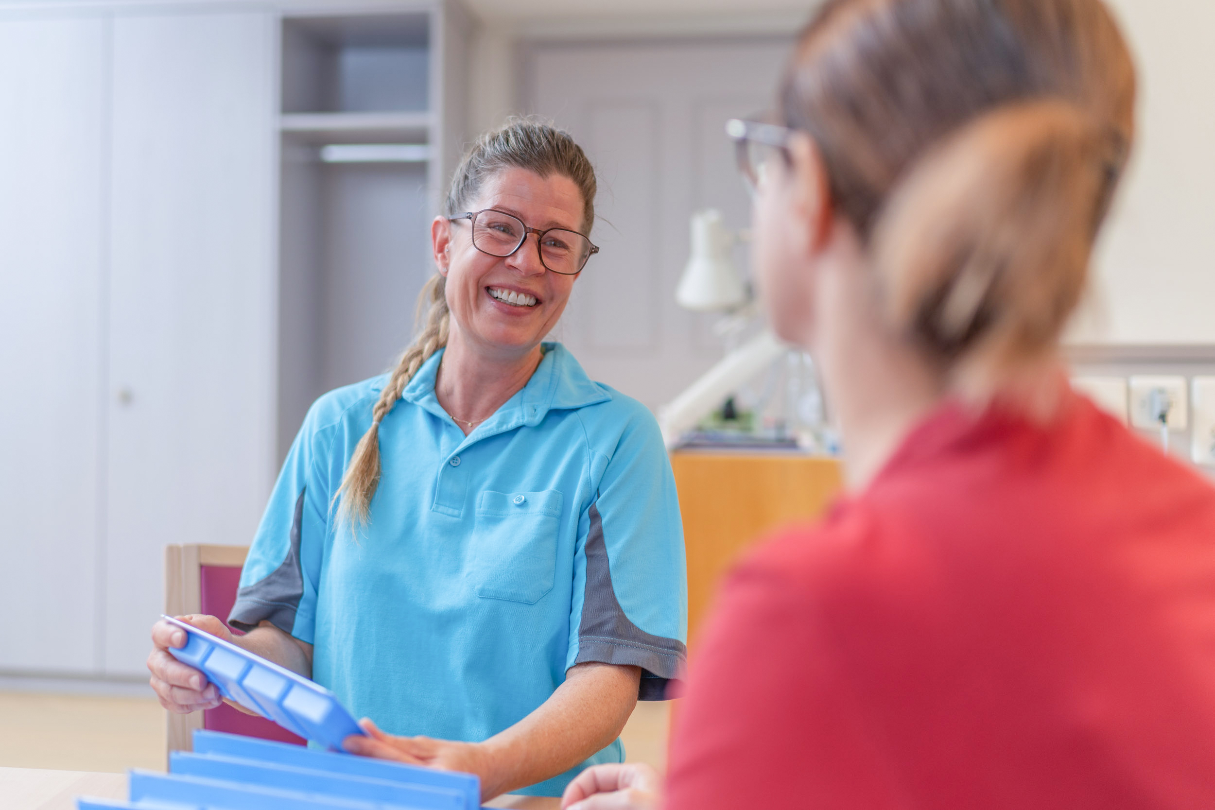 Pflegefachfrau lachend mit Patientin